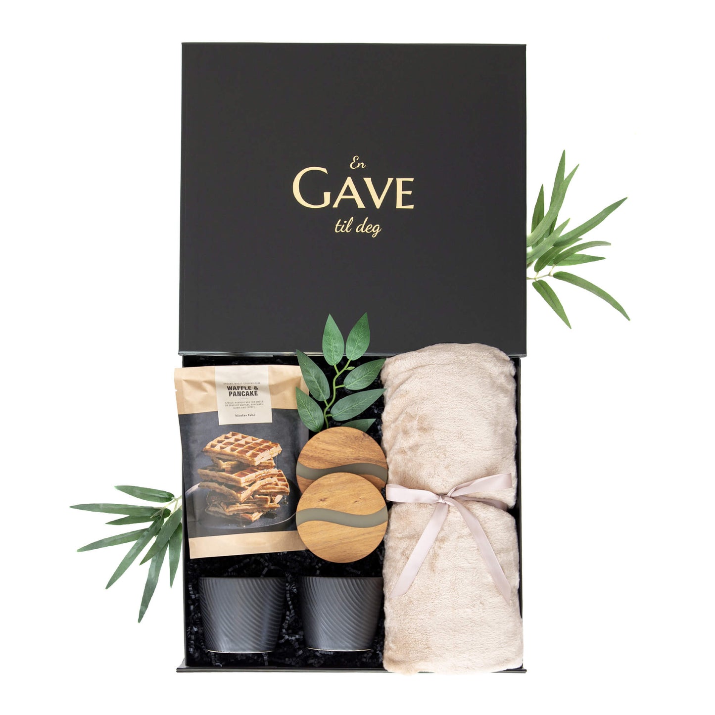 Gave med svarte kopper, bordbrikekr i akasietre, vaffelmix og et mykt deilig pledd. Pakket i en fin gaveeske med gullprint.