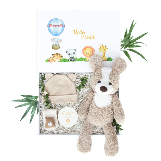Gave til nyfødt baby med lue og sokker i bomull og en super myk stor kosebamse, alt levert i en gaveeske med dyremotiv på innsiden.
