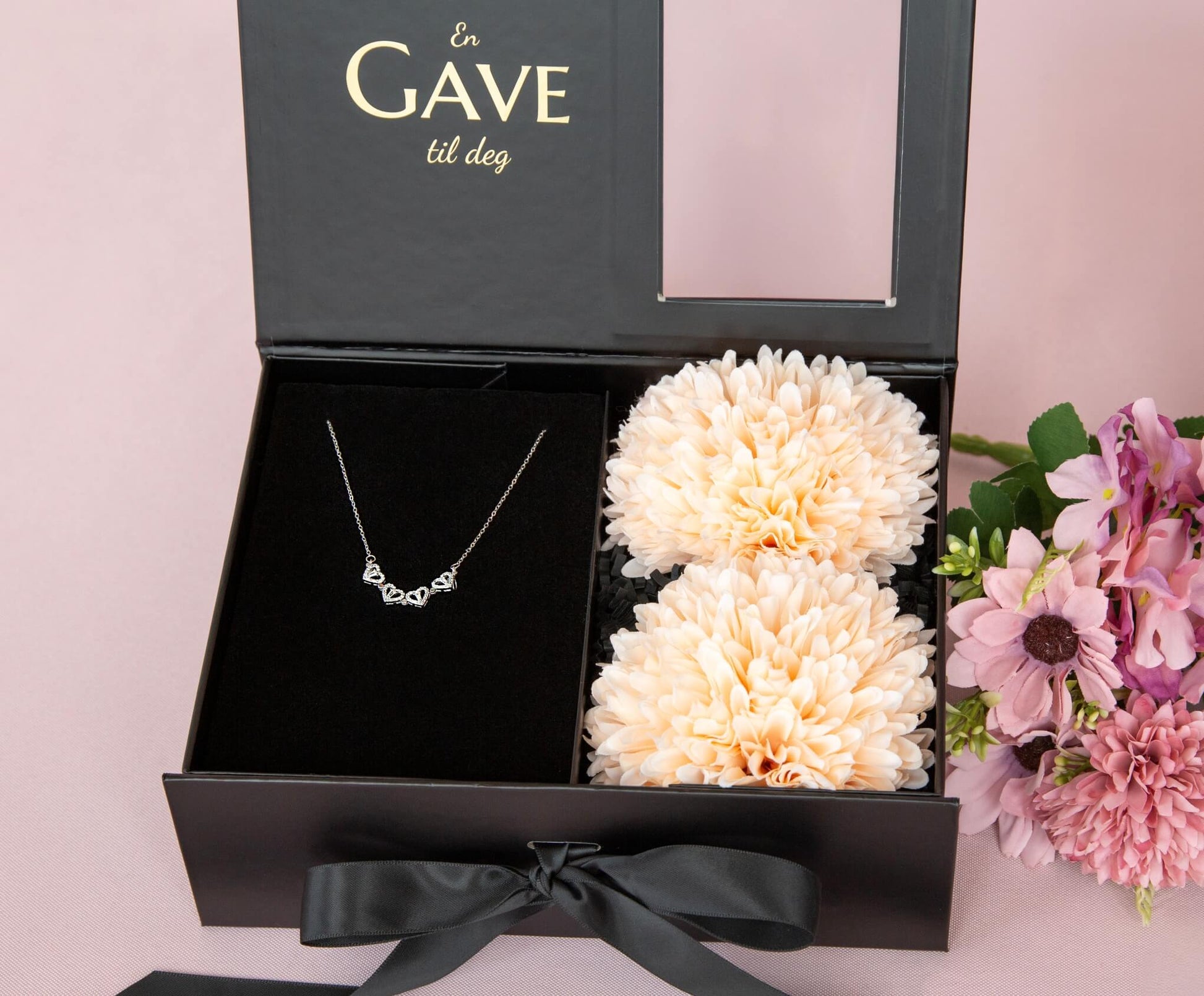 Hjertesmykke med zirkonia stener og fine blomster i en gaveeske.