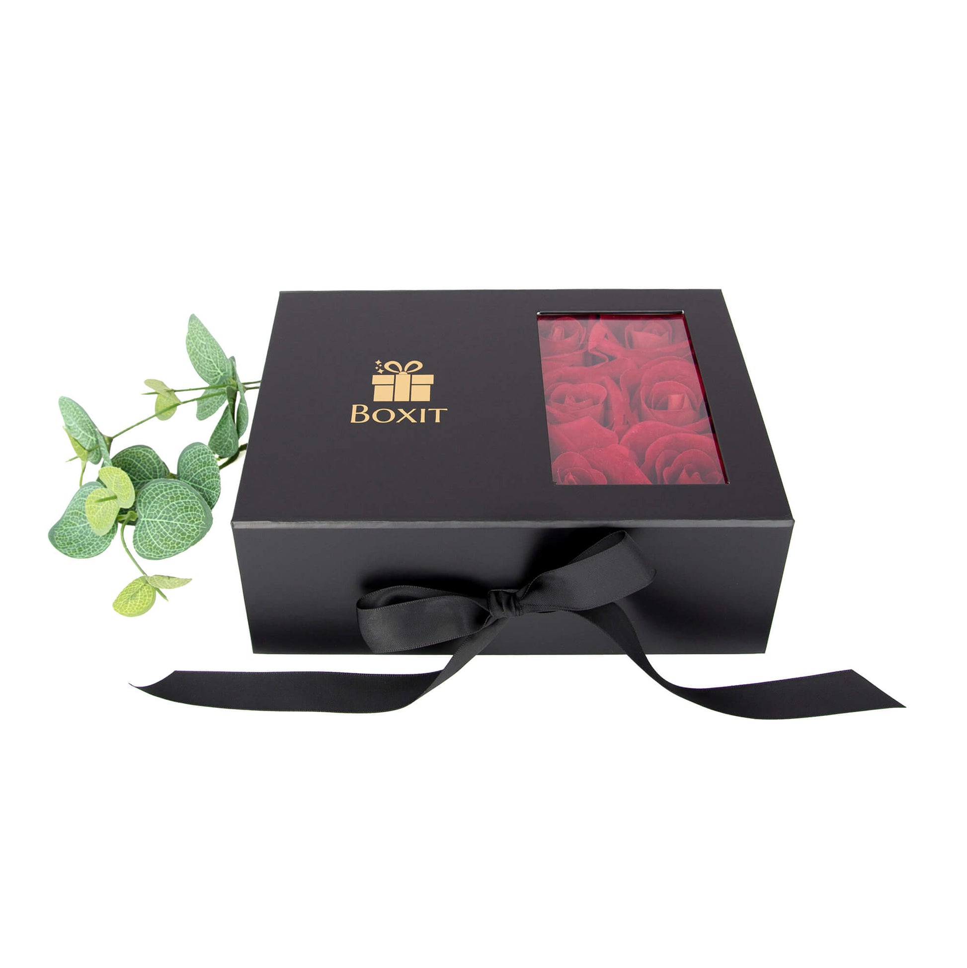 Lukket gaveeske med gull logo og svart silkebånd. Røde roser kan ses inne i gaven. Passer perfekt til en spesiell anledning.