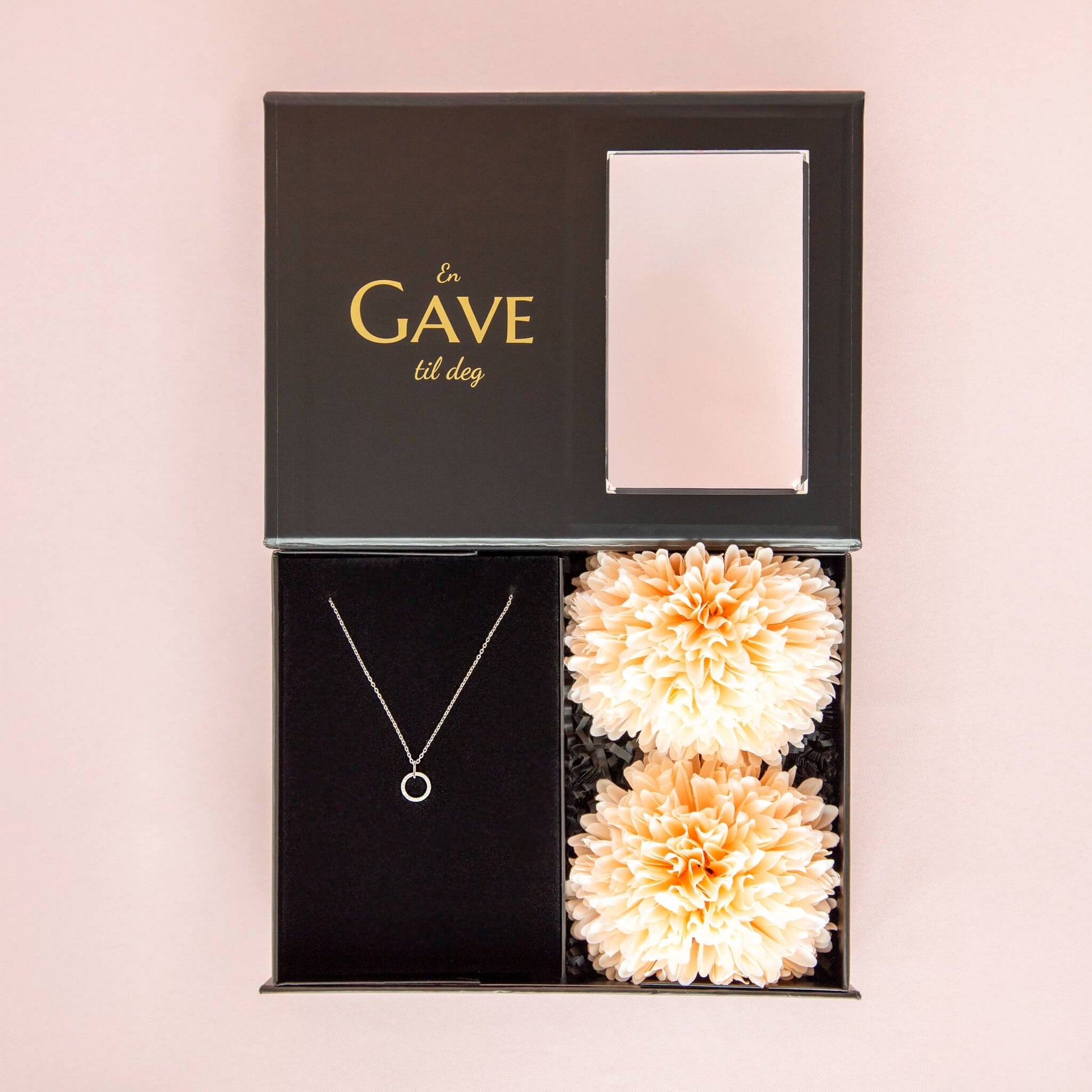 Gave til henne med rundt sølvsmykke og ferksenfargede blomster.