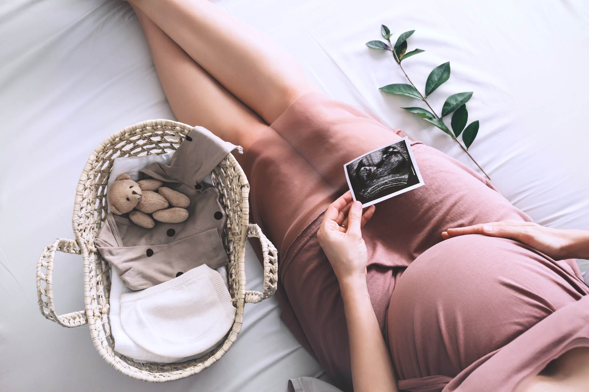 Gravid kvinne med ultralydbilde og babyutstyr – en koselig gaveidé til babyshower eller ventetiden