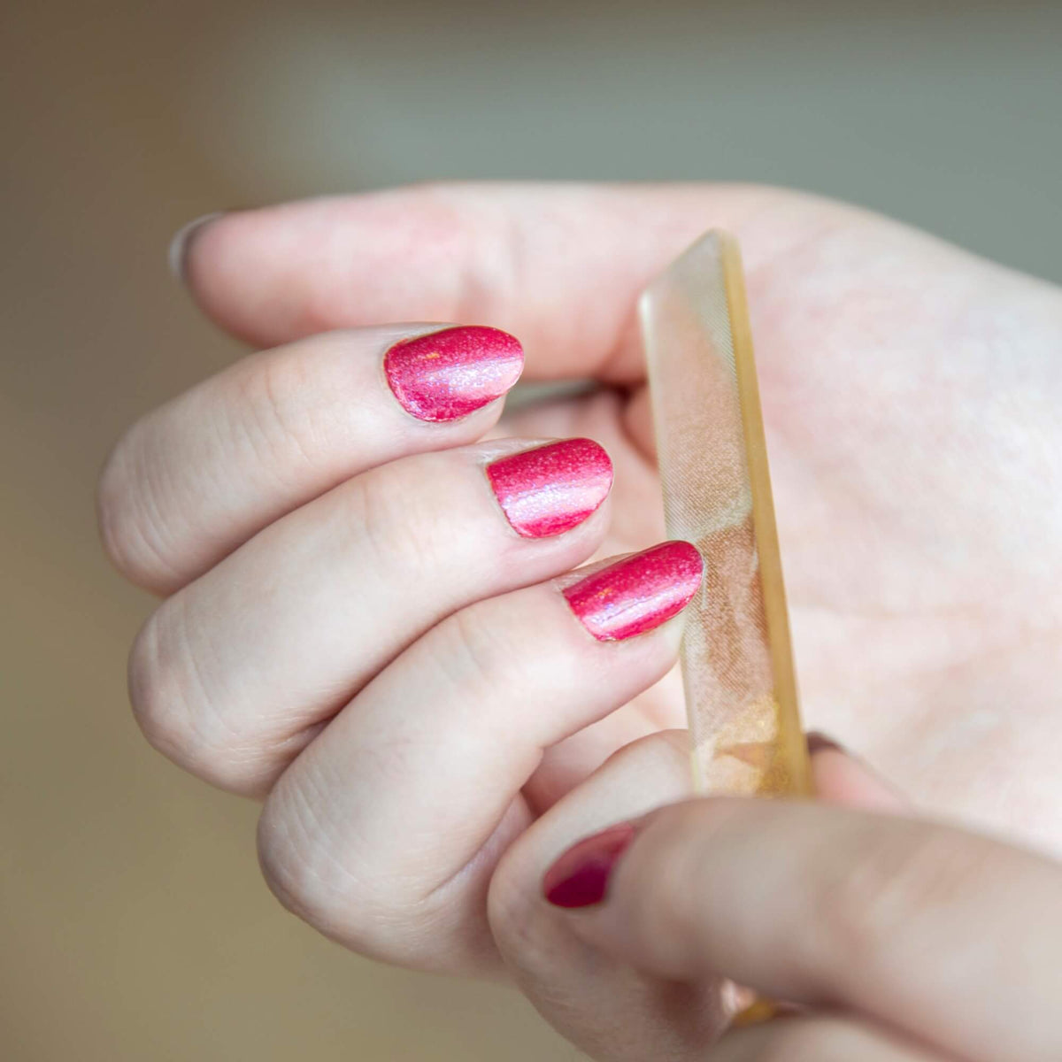 Gullfarget neglefil brukt på rosa lakkerte negler