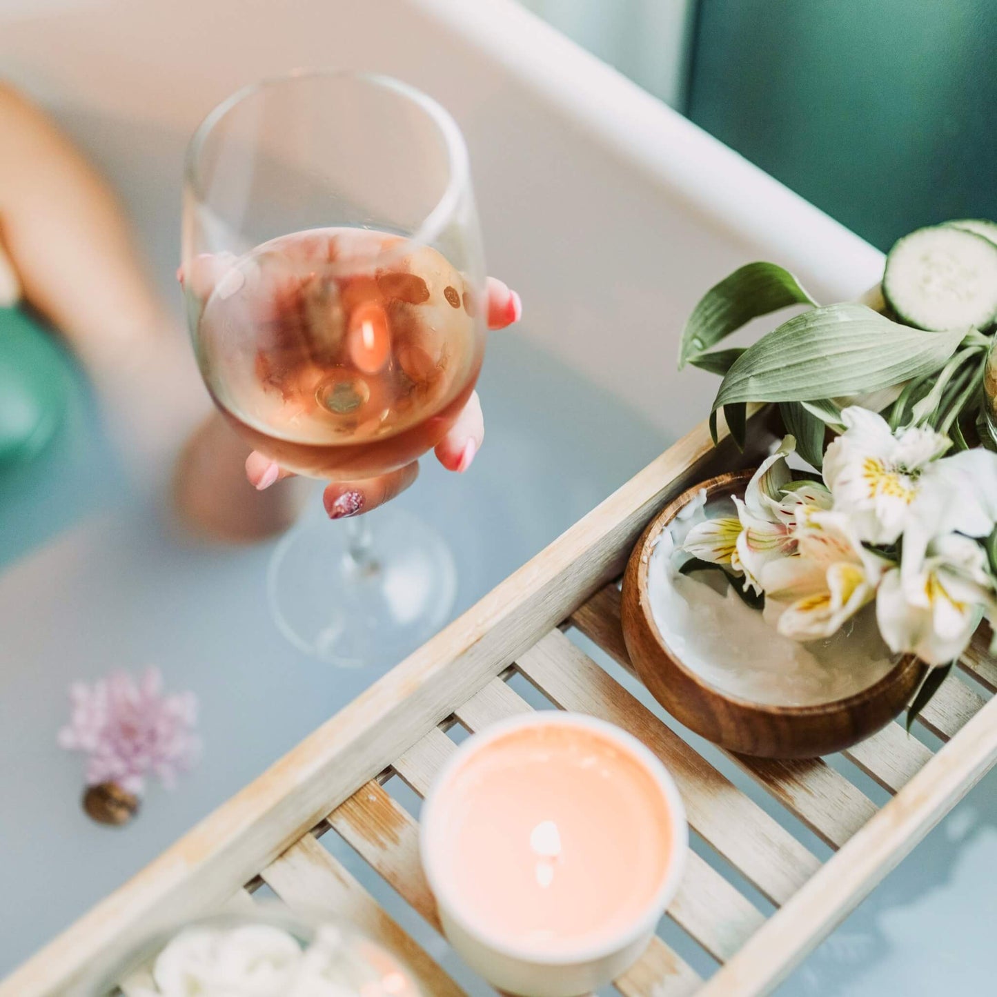 Dame i badekar med duftlys og vinglass som gir velvære og spa følelse.