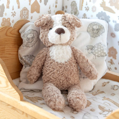 Mellomstor bamse som sitter pent i en krybbe.