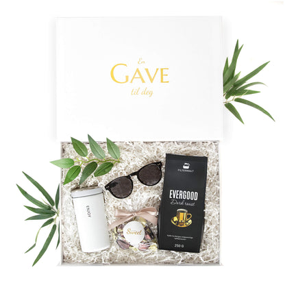 Gave til henne med termokopp, solbriller, sjokolade og brasiliansk kaffe i en gaveeske med gullskrift.