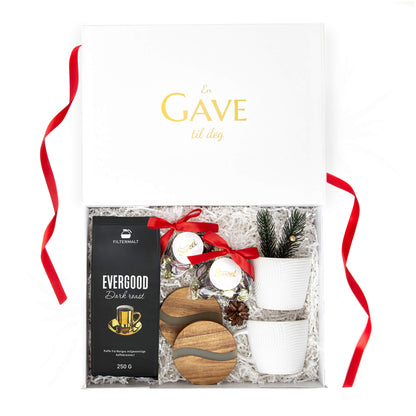 Kaffe, sjokolade, bordbrikker og hvite kopper i en hvit gaveeske med juledekor. Passer som julegave til både han og henne.