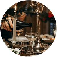 Vin skjenkes i glass ved et dekket julebord.
