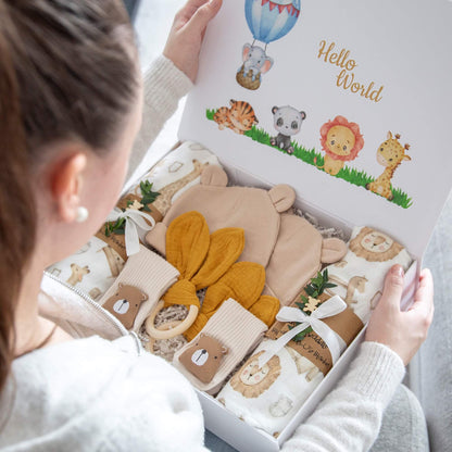Babygaveesken It’s Twins med to pledd, to luer, to par sokker og to rangler, pakket i hvit gaveeske med dyremotiv.