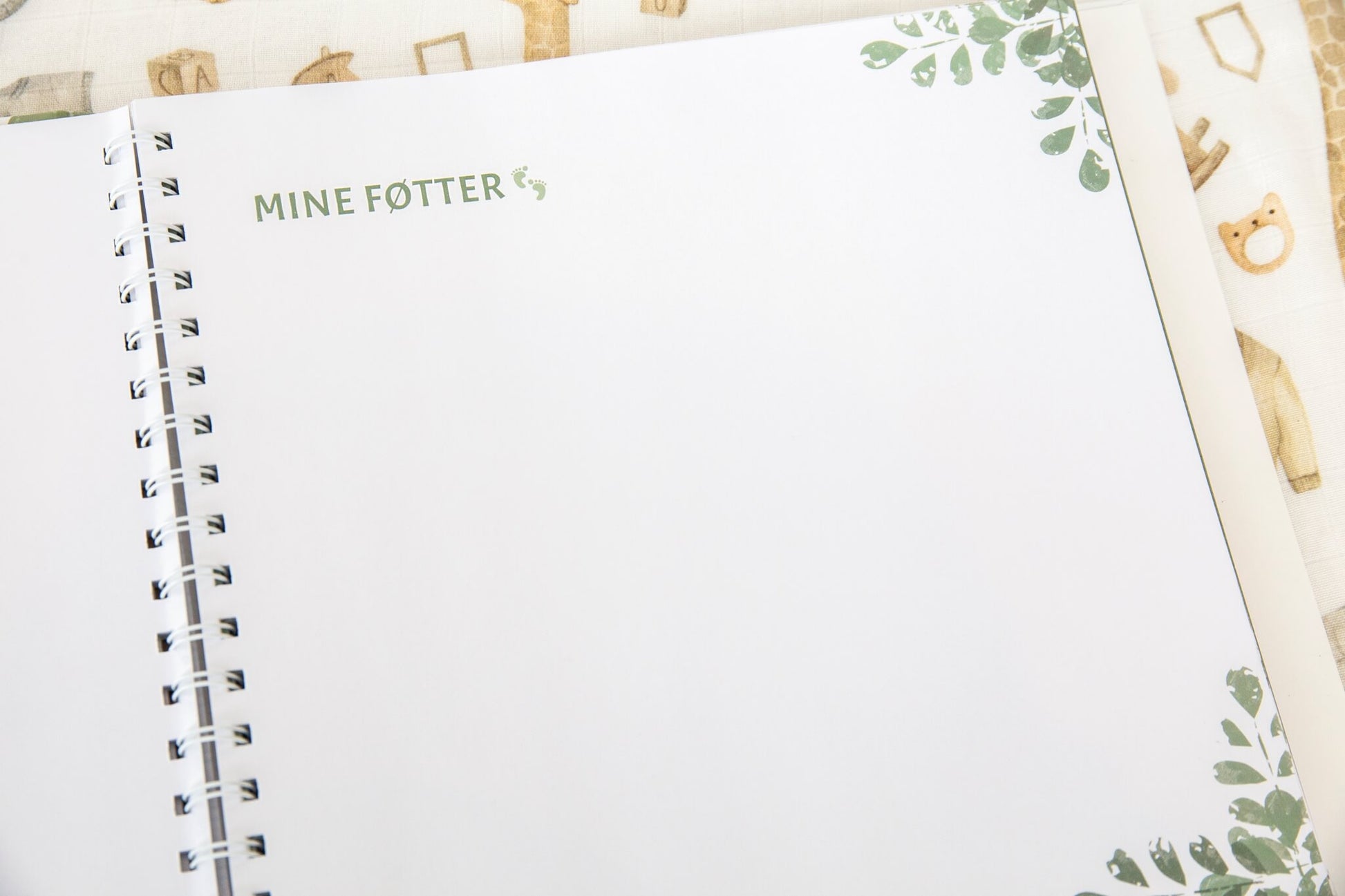 En side fra en nydelig babyjournal hvor de nybakte foreldrene kan dokumentere det første året til sin nyfødte baby.