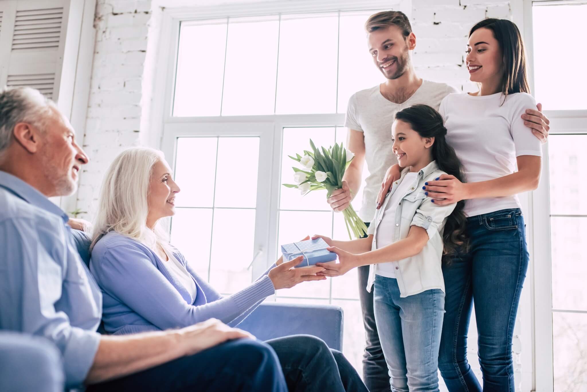 Familie overrekker med fellesgave til besteforeldre – perfekt gaveidé til foreldre eller besteforeldre