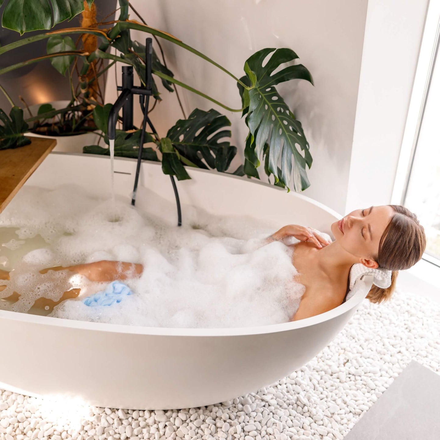 Dame som har brukt velvære produkter til å ta et avslappende bad.