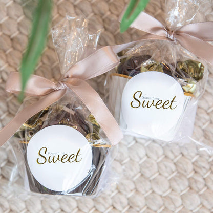 To gaveposer med innpakkede fondantsjokolader og Something Sweet-etikett