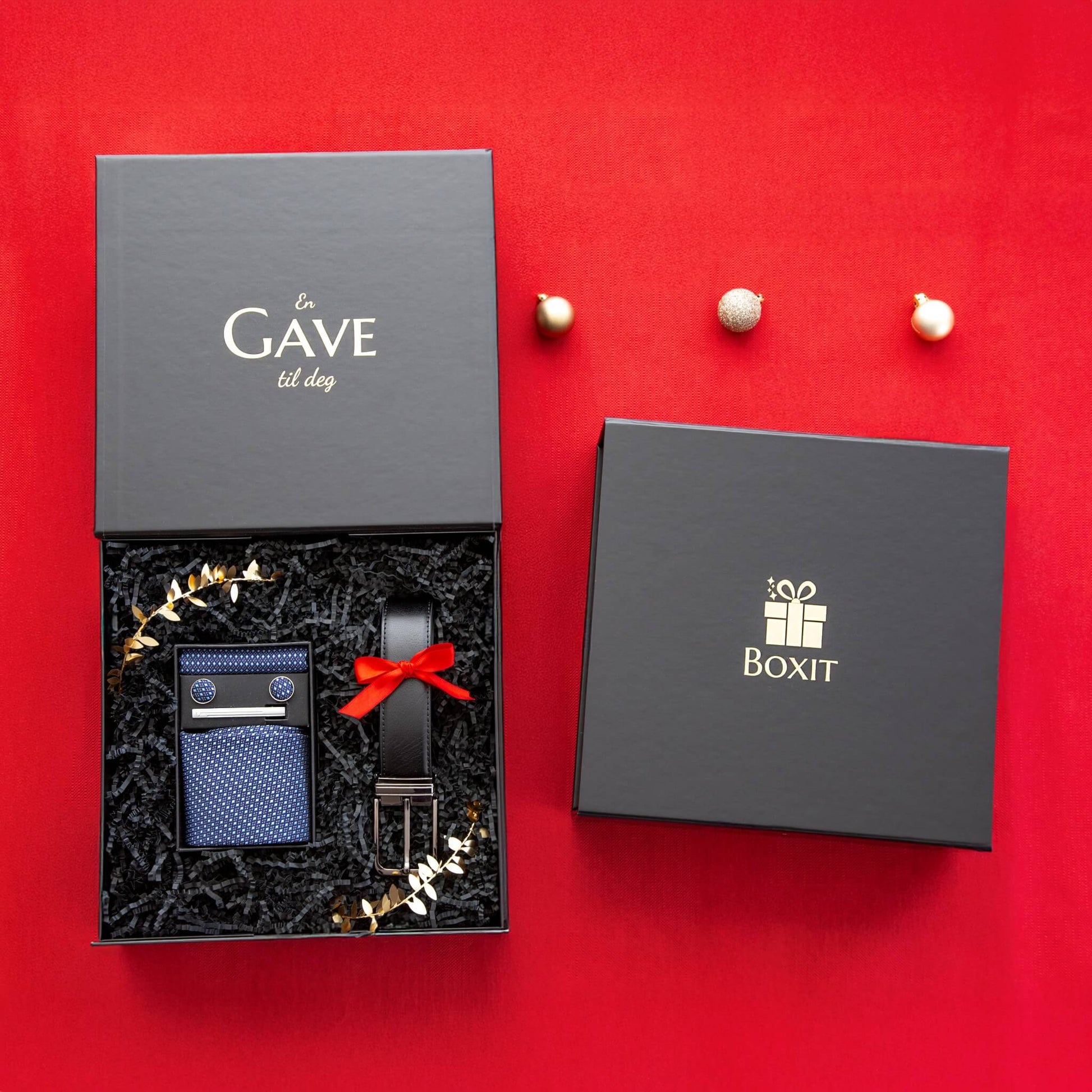 En åpen svart gaveeske med kvalitetsprodukter og en lukket svart gaveeske. Eksklusive gaver til jul.