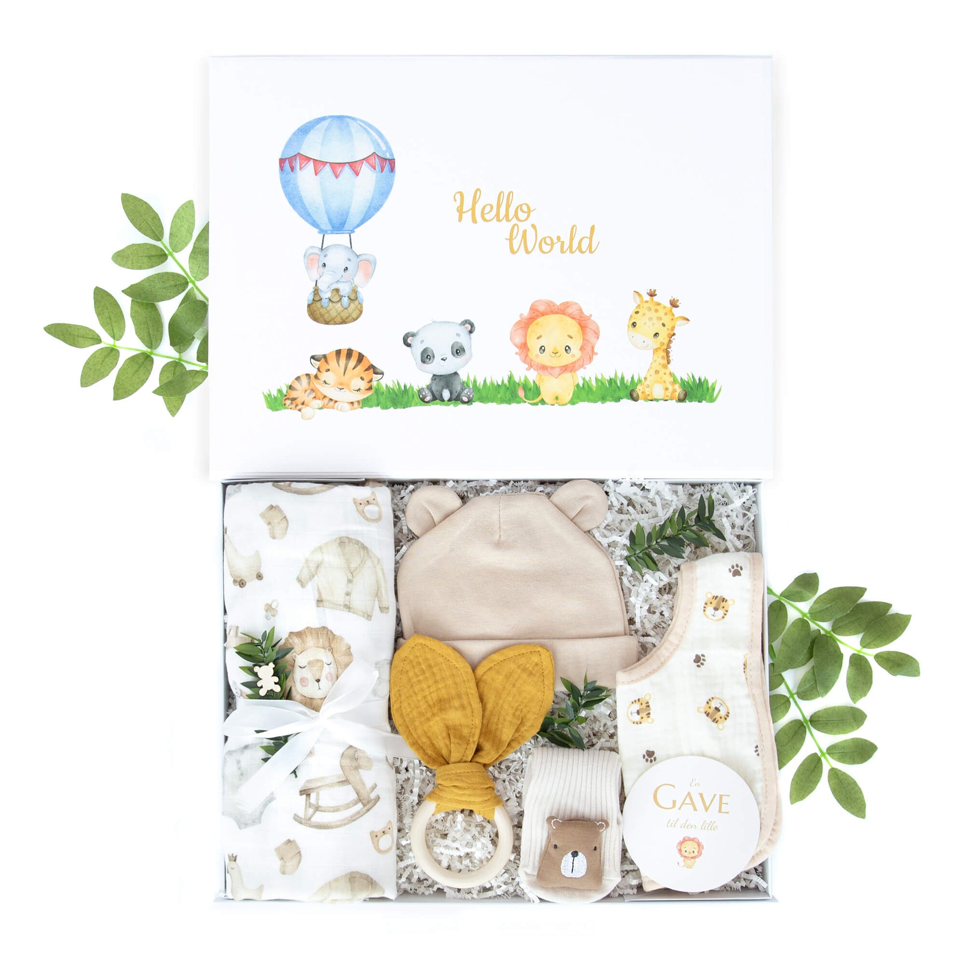 Gave til nyfødt baby med musslin teppe, rangle, babylue, sokker med bjørn og smekke med løveprint.