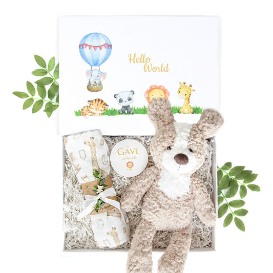 Babygave med kosebamse og musslinpledd i en hvit gaveeske.