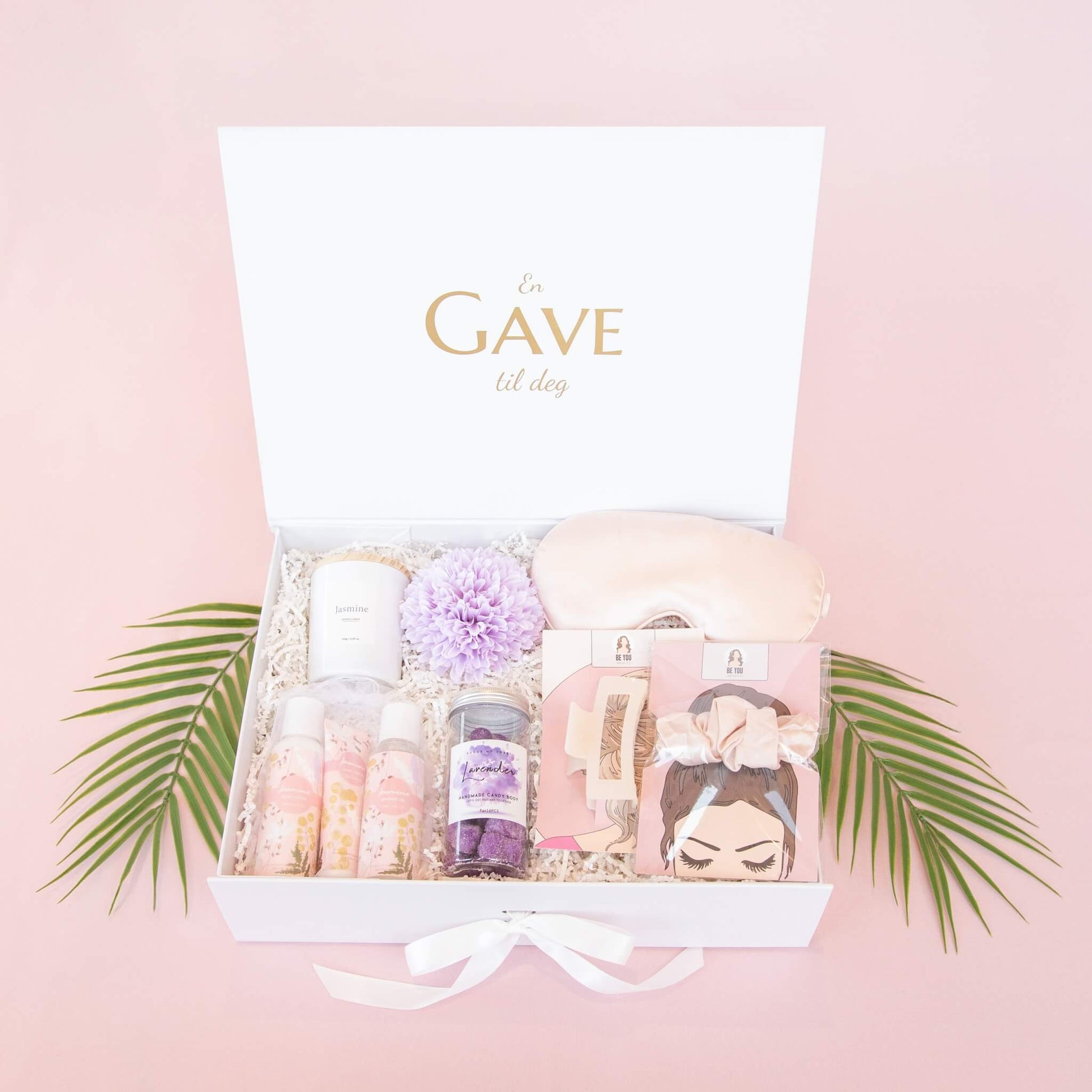 Velvære gave til henne med badesett, duftlys, bodyscrub, sovemaske, hårstrikk og hårklipe. Elegant pakket i en gaveeske fra Boxit.