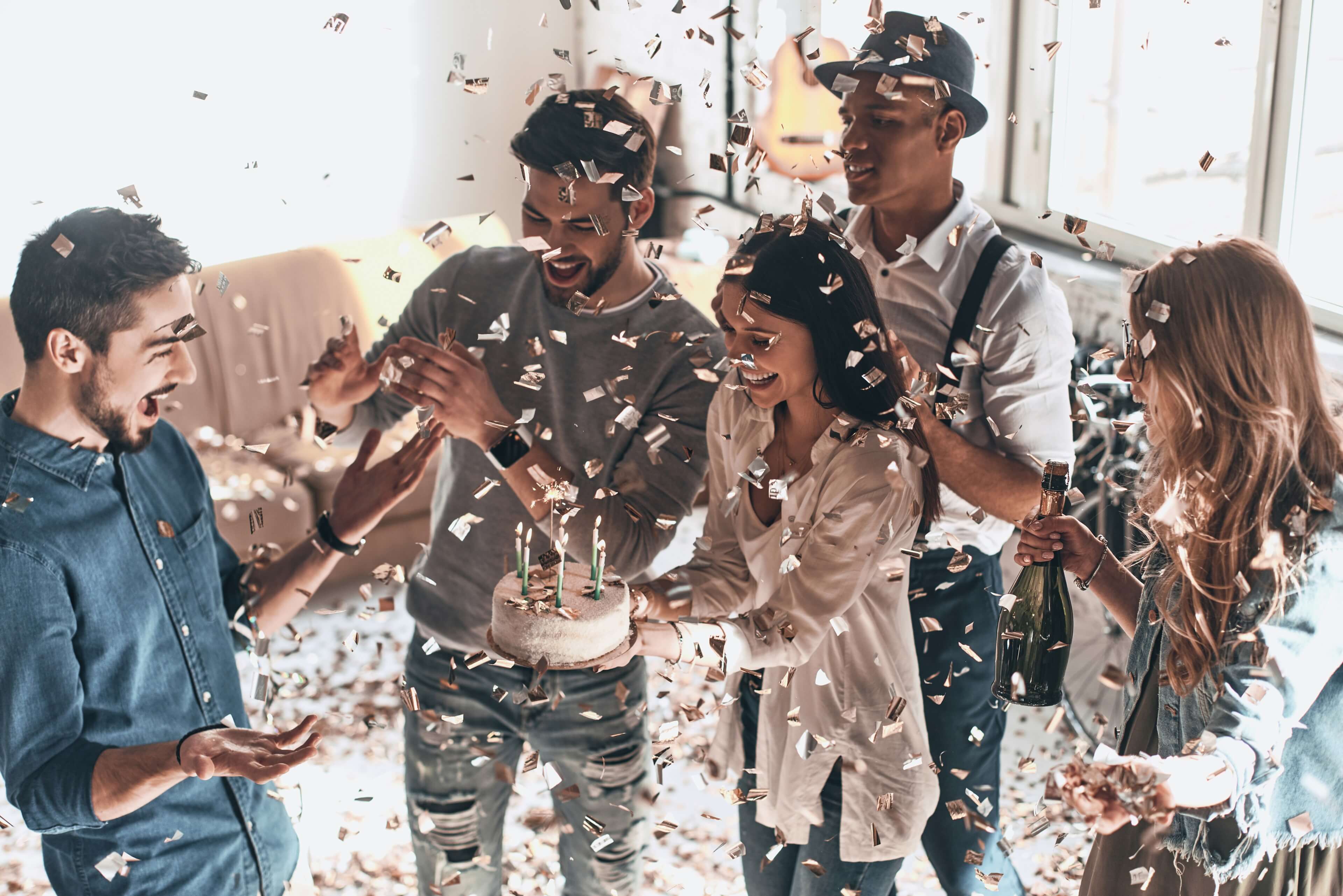 Gruppe som feirer med bursdagskake, konfetti og champagne, illustrerer gaver til alle anledninger som bursdag, jubileum og feiringer.