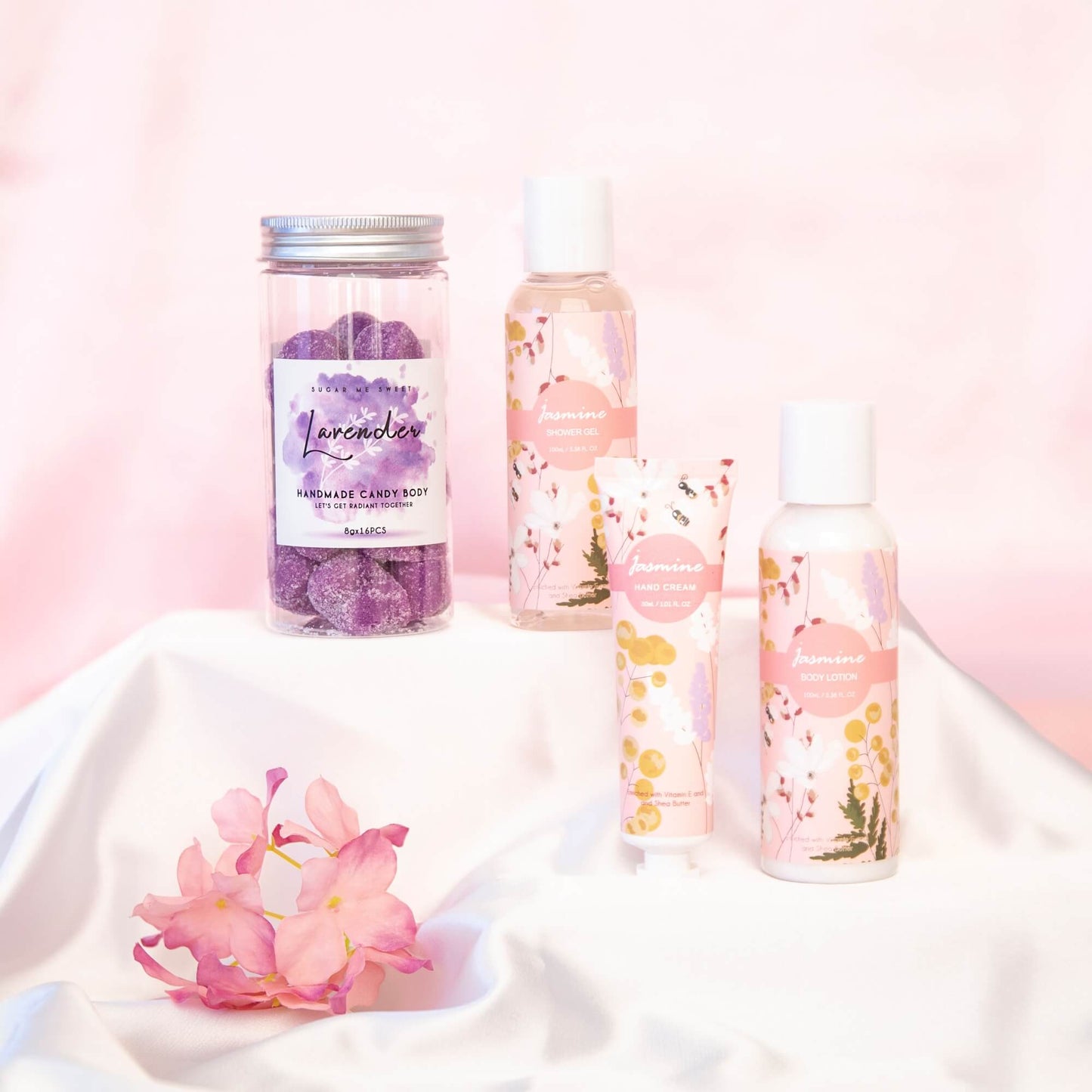 Badesett i jasmin og Lavendel bodyscrub presentert på et silkeunderlag.