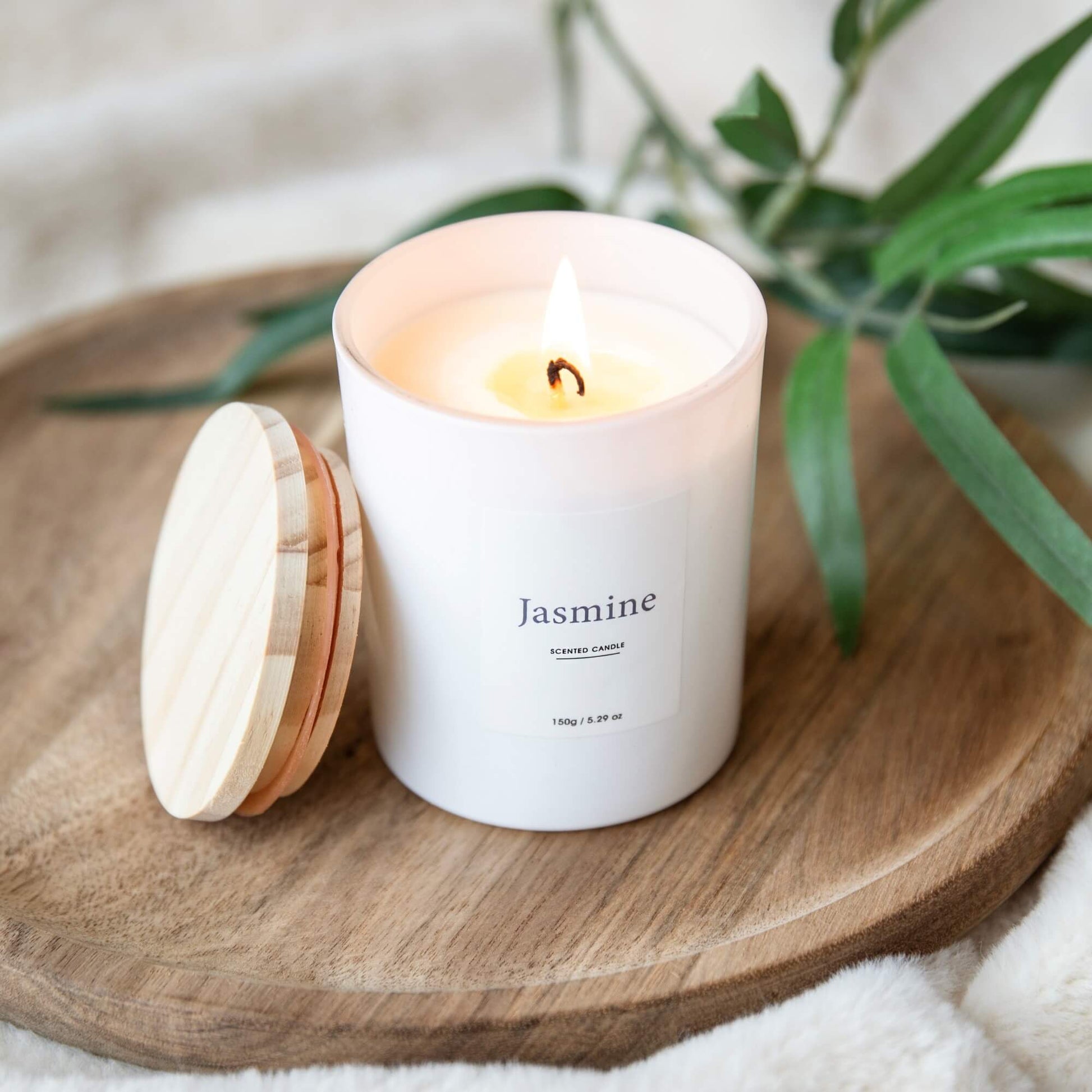 Tent Jasmine-duftlys med trelokk plassert ved siden av