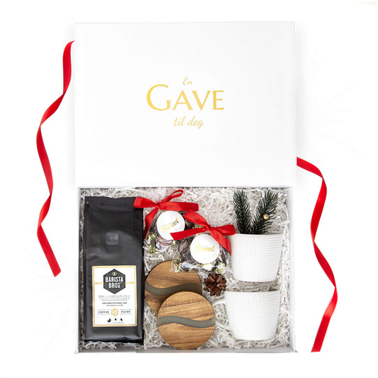 Kaffe, sjokolade, bordbrikker og hvite kopper i en hvit gaveeske med juledekor. Passer som julegave til både han og henne.