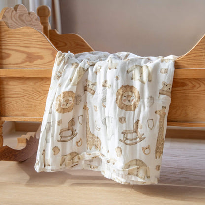 Babypledd med fine dyremotiver som henger over en krybbe.