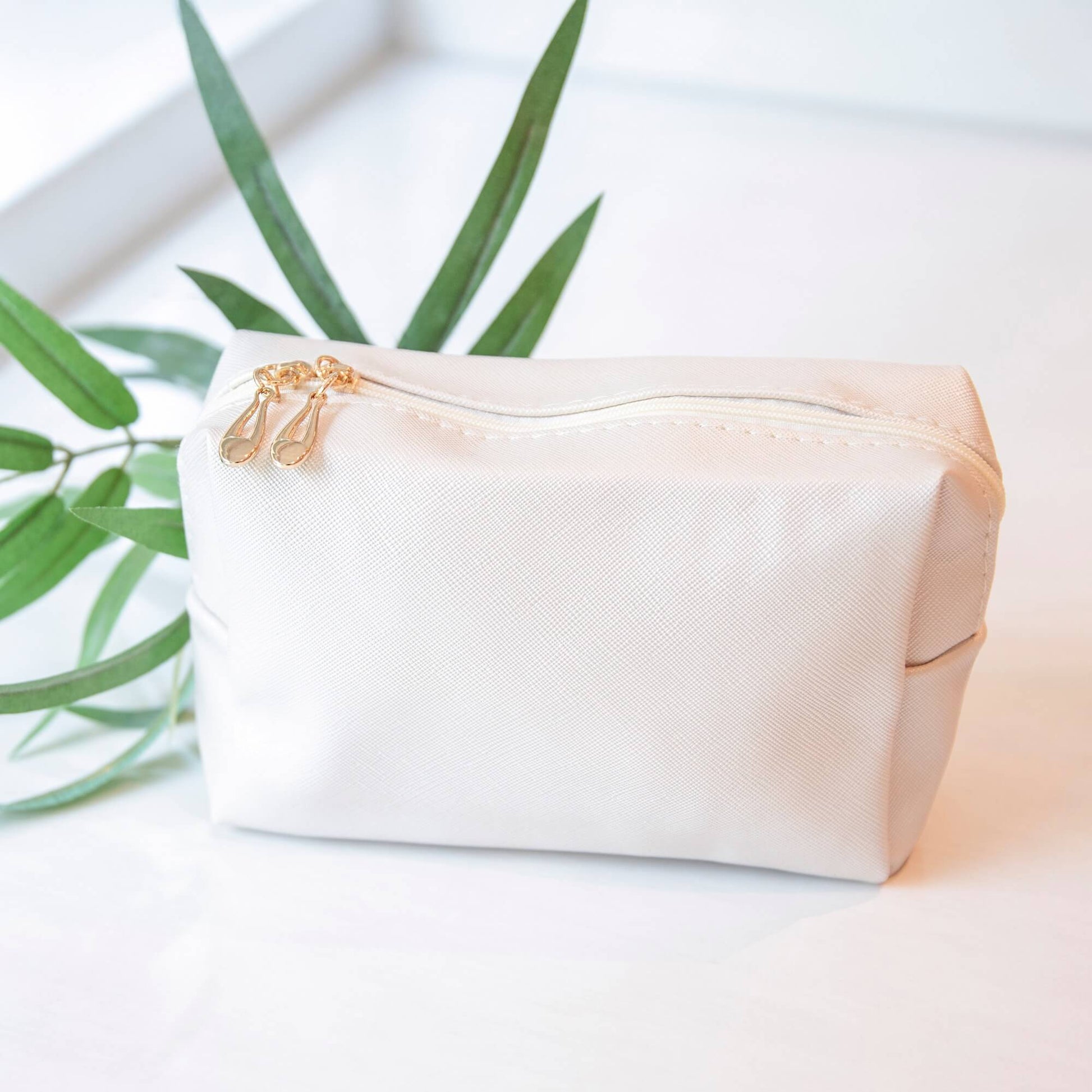 Beige toalettmappe med doble gullfargede glidelåser